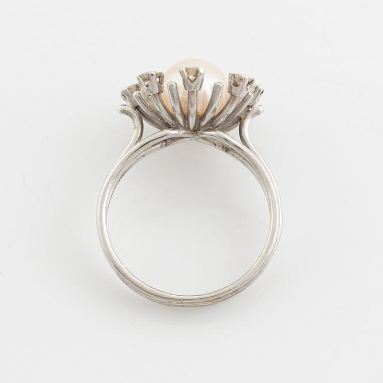 An 18K gold ring set with a cultured pearl and round brilliant-cut diamonds.