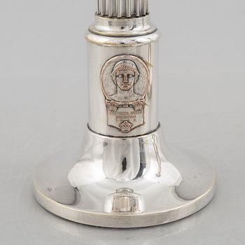 A pair of candlesticks and a commemorative pin from the Olympic Games in Stockholm 1912.