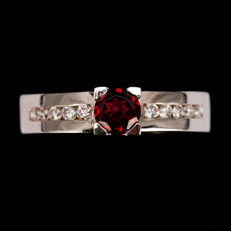 RING, vitguld 14K, fasettslipad granat 0,49 ct, briljantslipade diamanter diamanter tot. 0,21 ct. Vikt 4,7 g.
