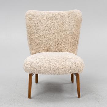 A mid 20th Century easy chair with sheepskin upholstery.