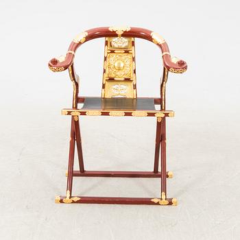 A laqcuered wooden chair from China 21st century.
