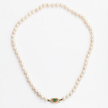 A cultured pearl necklace, clasp 18K gold with emerald and small diamonds.