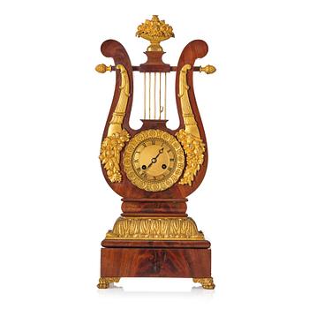 130. A French Empire mahogany, ormolu and gilt metal lyre-shaped mantel clock, early 19th century.