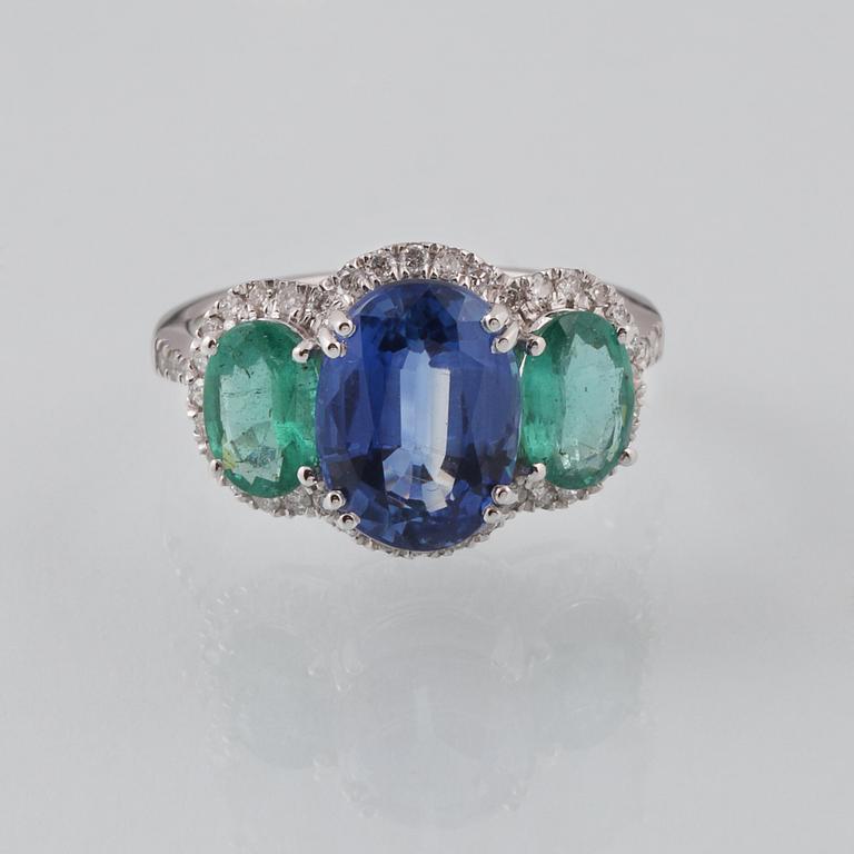 RING, 18K vitguld med fasettslipad kyanit 3.49 ct, 2 smaragder 1.23 ct och briljantslipade diamanter 0.33 ct. Vikt 3 g.
