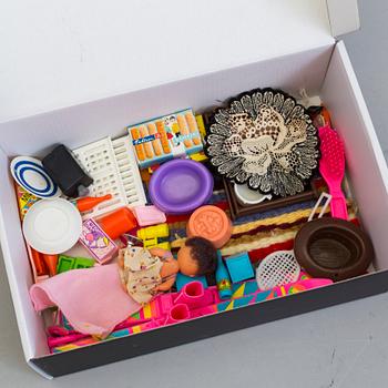 A plastic doll's house with six dolls, furniture and clothes, 20th century.