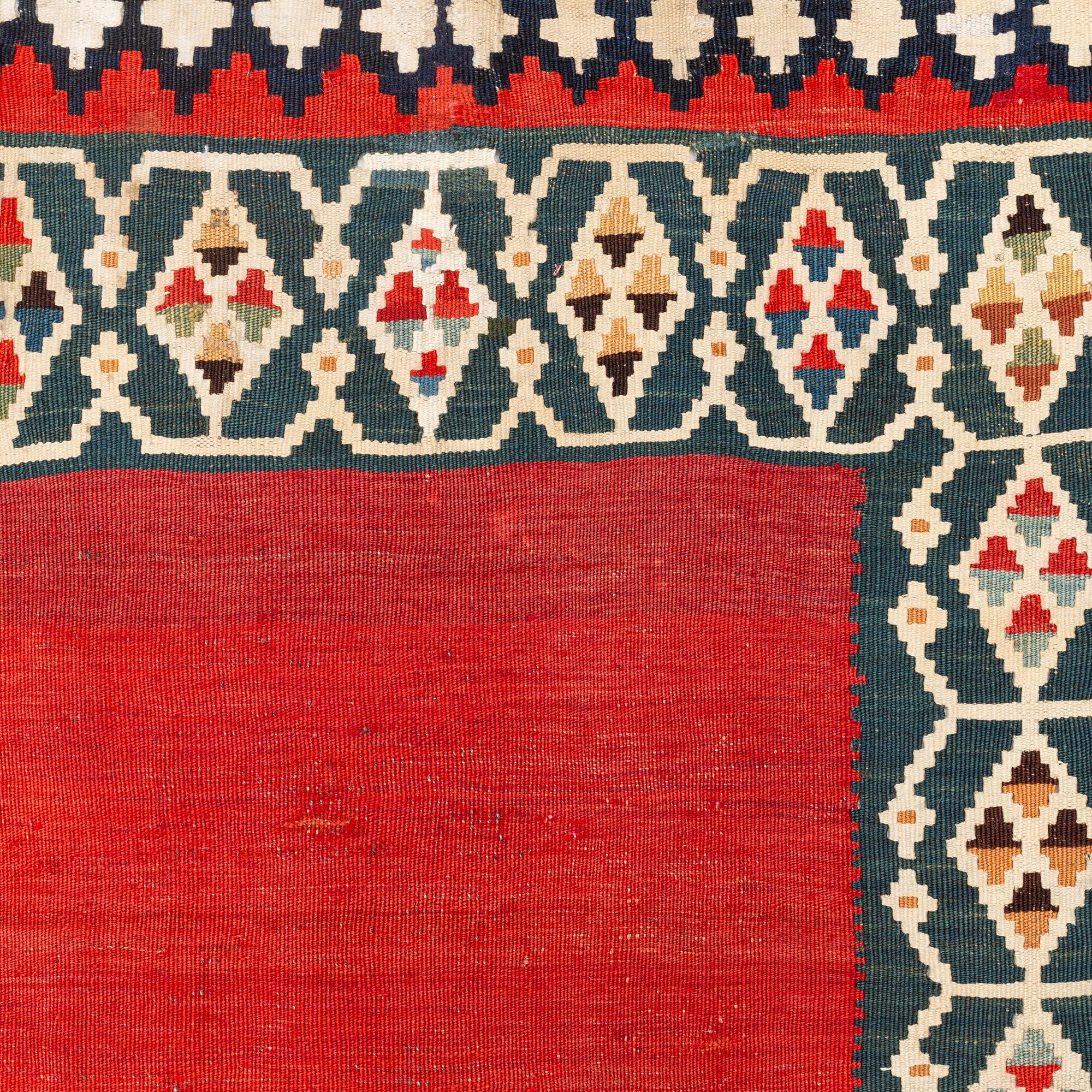An antique Qashqai kilim rug, approximately 240 x 155 cm.