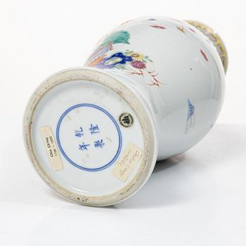 A slender famille rose 'flowers and antiques' vase, late Qing dynasty/early 20th century.
