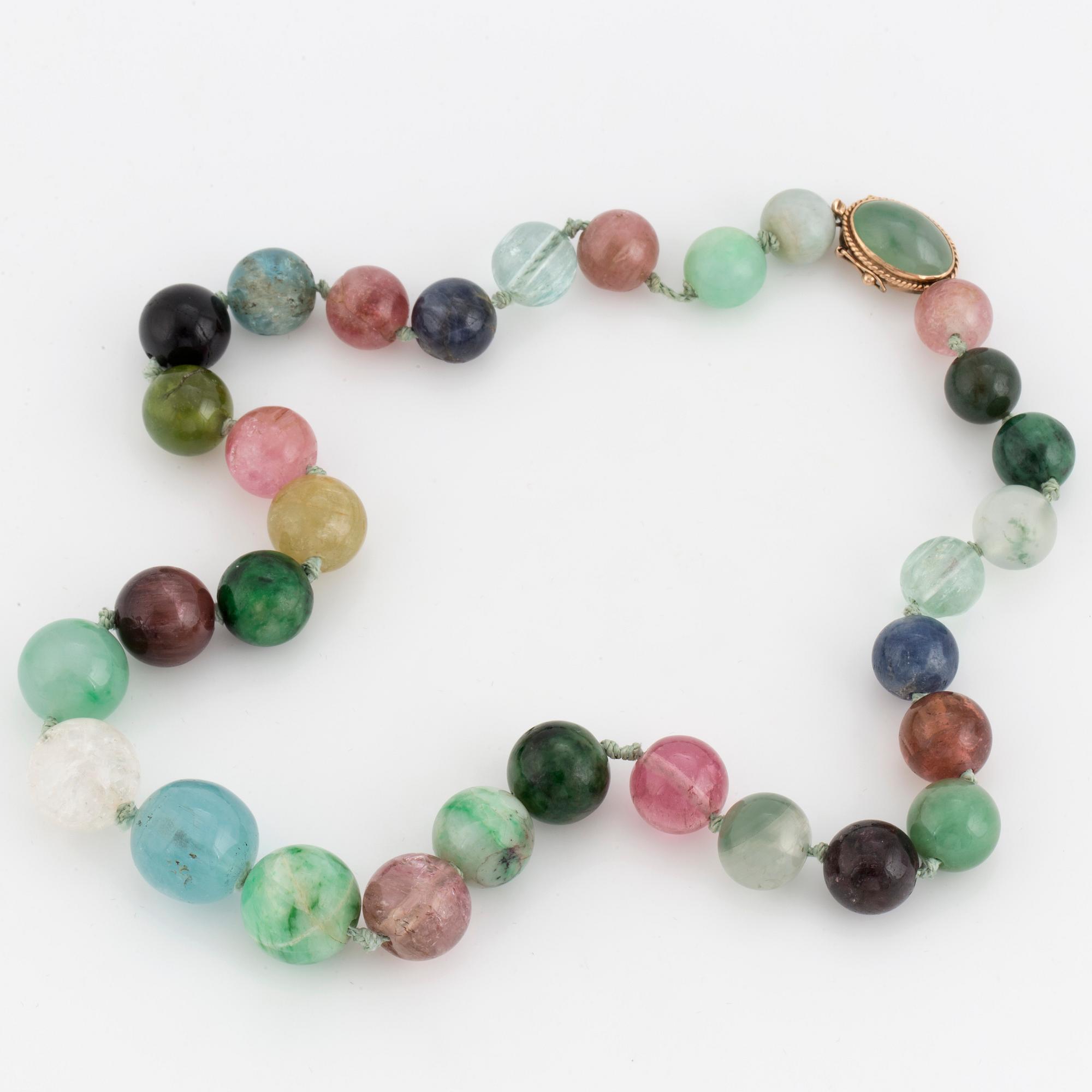 A necklace of multi-coloured stone beads with an 14K gold clasp.