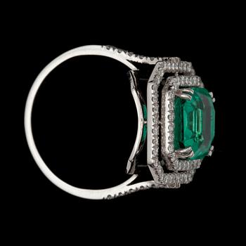 A 4.31 ct Colombian emerald surrounded by brilliant-cut diamonds, total carat weight circa 0.64 ct.