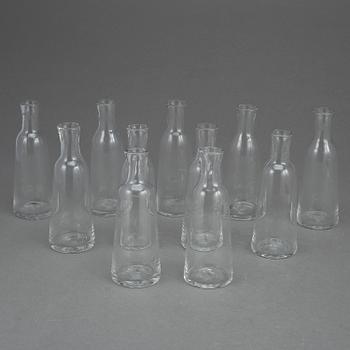 BRÄNNVINSGUMMOR/BRÄNNVINSFLASKOR, 11 st. Omkring 1800-talets andra hälft. Munblåst klar glasmassa.