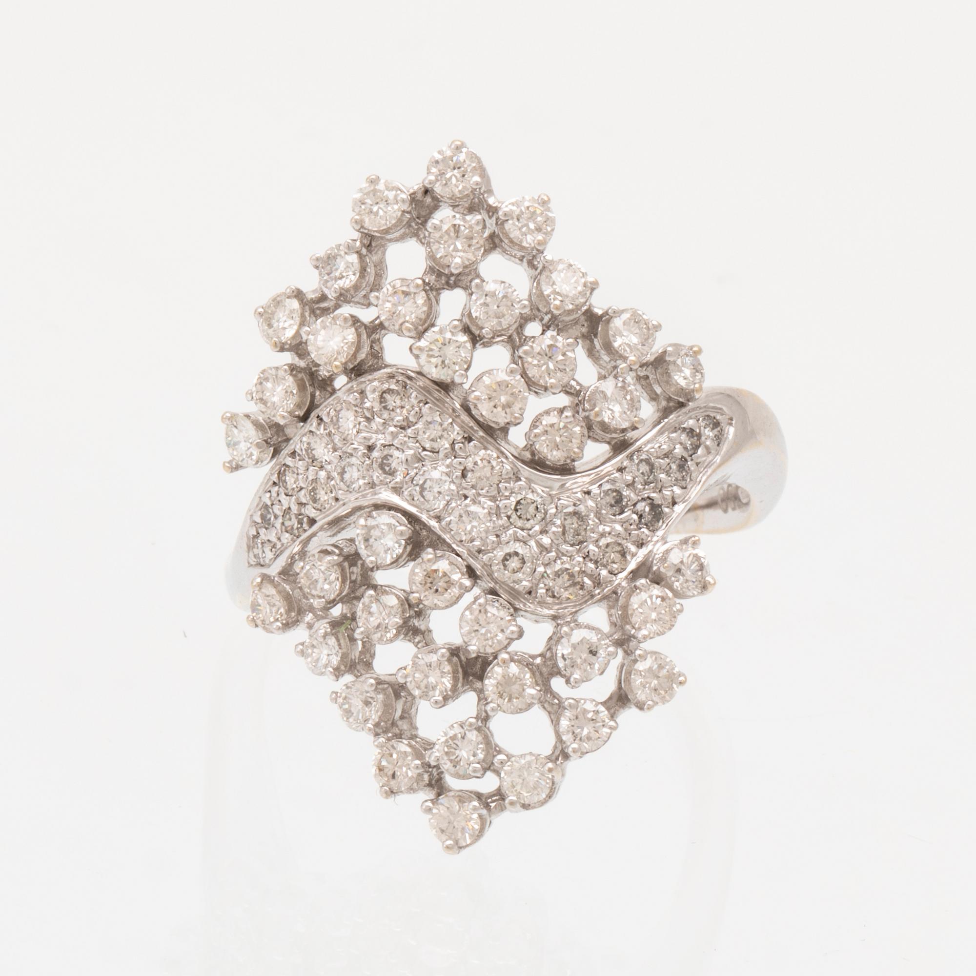 An 18K white gold ring set with round brilliant cut diamonds.