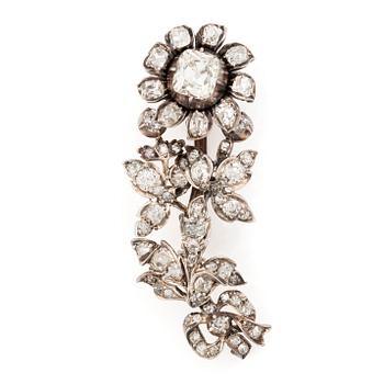 A flower silver brooch set with old-cut diamonds.