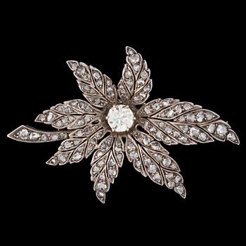 1106. An antique- and rose cut diamond brooch of floral design, center stone app. 1.10 ct.