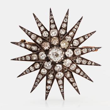 1035. A star brooch in 14K gold and silver set with old-cut diamonds.