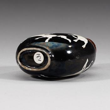 An enamelled porcelain snuff bottle with stopper, Qing dynasty (1644-1912).