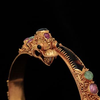 ARMBAND, 22k guld med flertal trumlade ädelstenar, bla. rubiner och smaragder. Vikt 26,9 g.