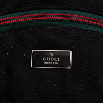 Gucci, a black canvas backpack.