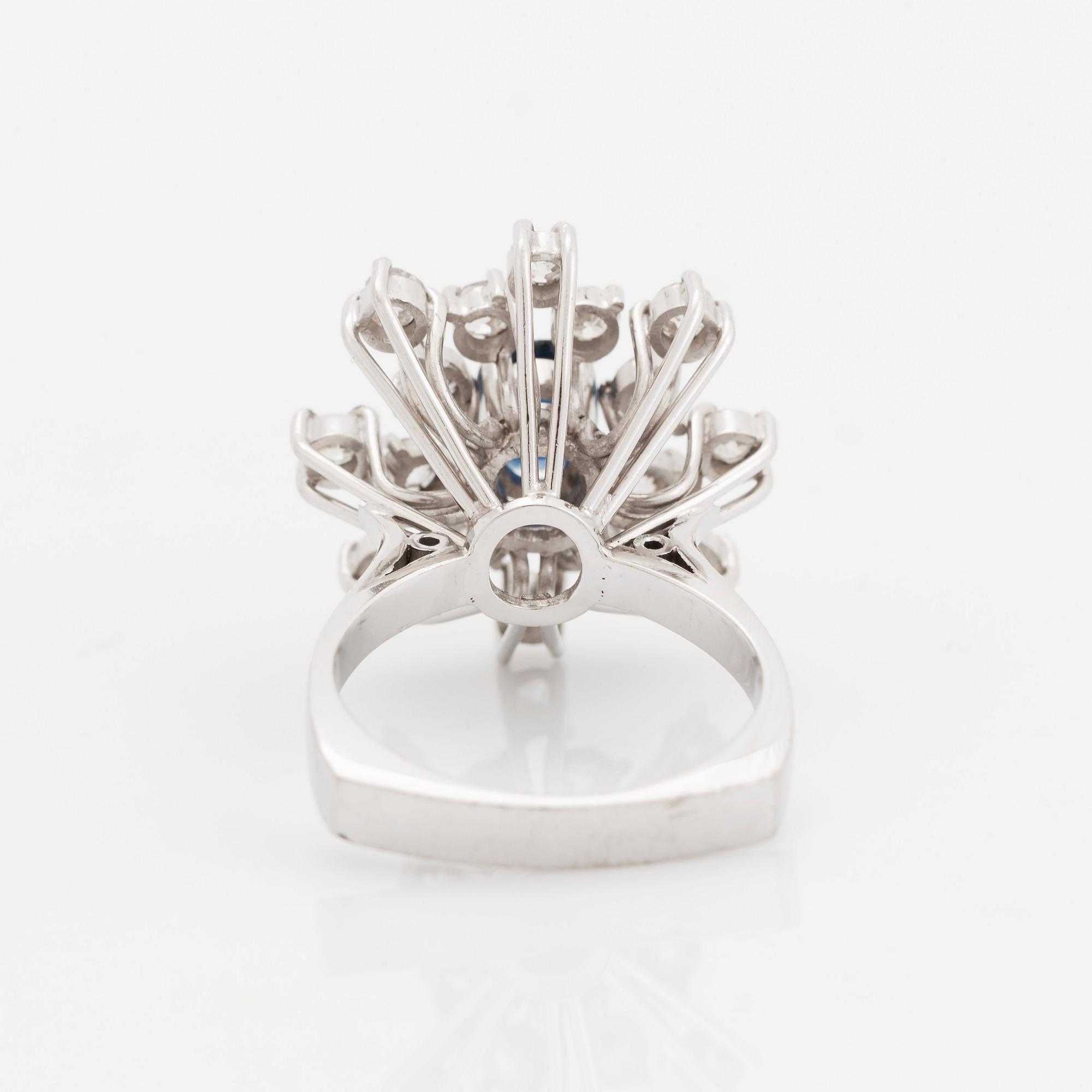 An 18K white gold ring set with a faceted sapphire and old-cut diamonds.