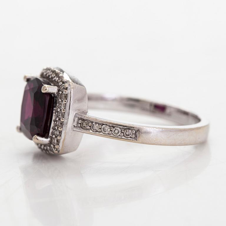 A 14K gold ring, with diamonds totalling approximately 0.095 ct and a garnet.