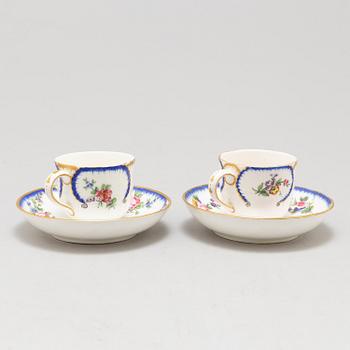 A pair of enamelled cups with dishes, France, Sèvres, 1780s.