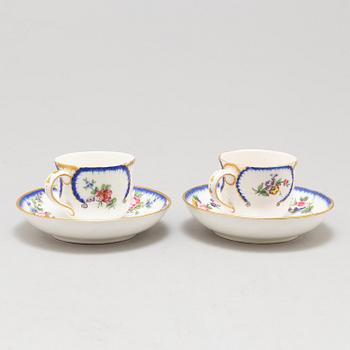 A pair of enamelled cups with dishes, France, Sèvres, 1780s.