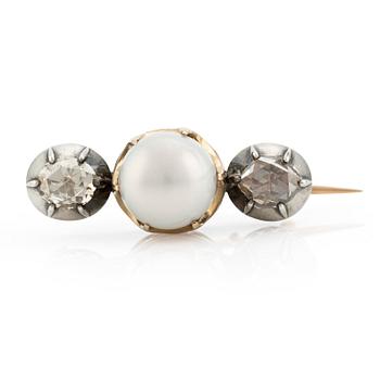 A brooch in silver and gold with a pearl and two rose-cut diamonds.
