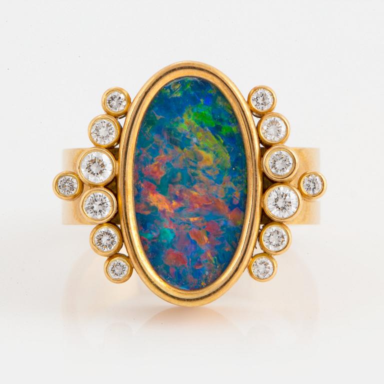An 18K gold and opal ring set with round brilliant-cut diamonds.