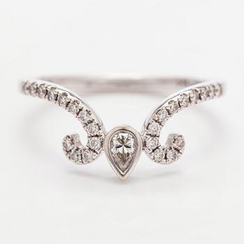 An 18K white gold ring set with a pear-shaped and brilliant-cut diamonds.