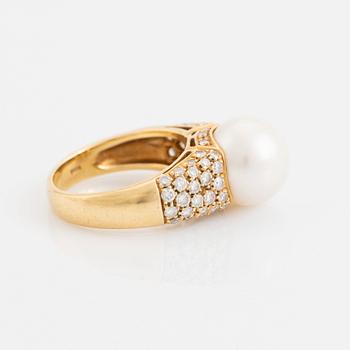 An 18K gold ring set with a cultured South Sea pearl and round brilliant-cut diamonds.