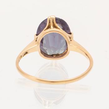 An 18K gold ring set with a synthetic colourchange purple sapphire.