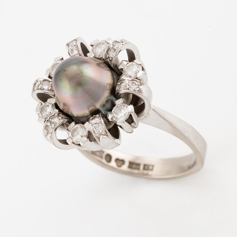 An 18K white gold ring set  with a pearl and round brilliant-cut diamonds.