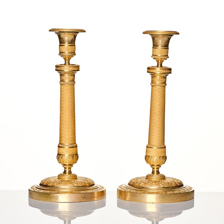 A pair of French gilded Empire candlesticks, early 19th century.