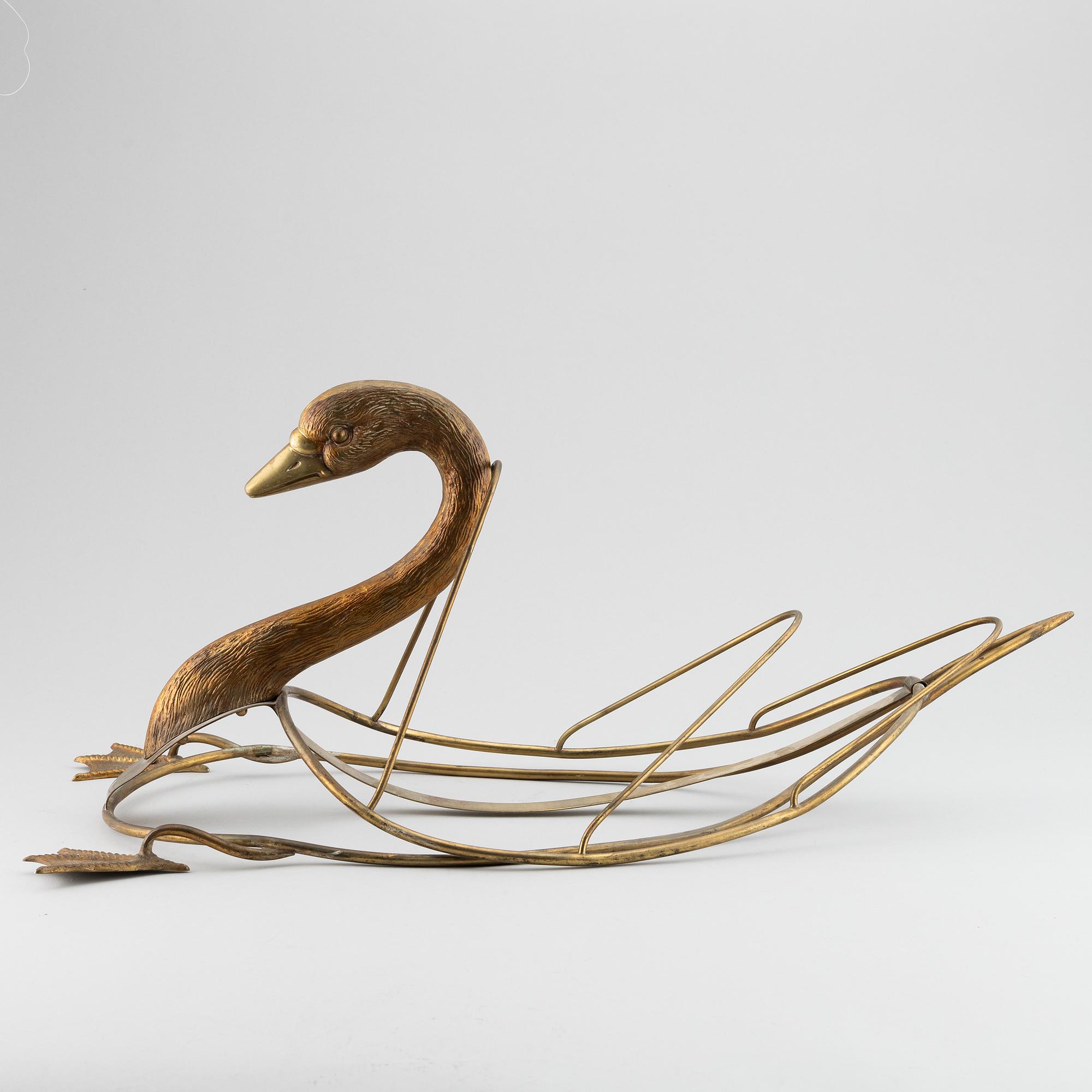 A 20th century grass newspaper stand in the shape of a swan.