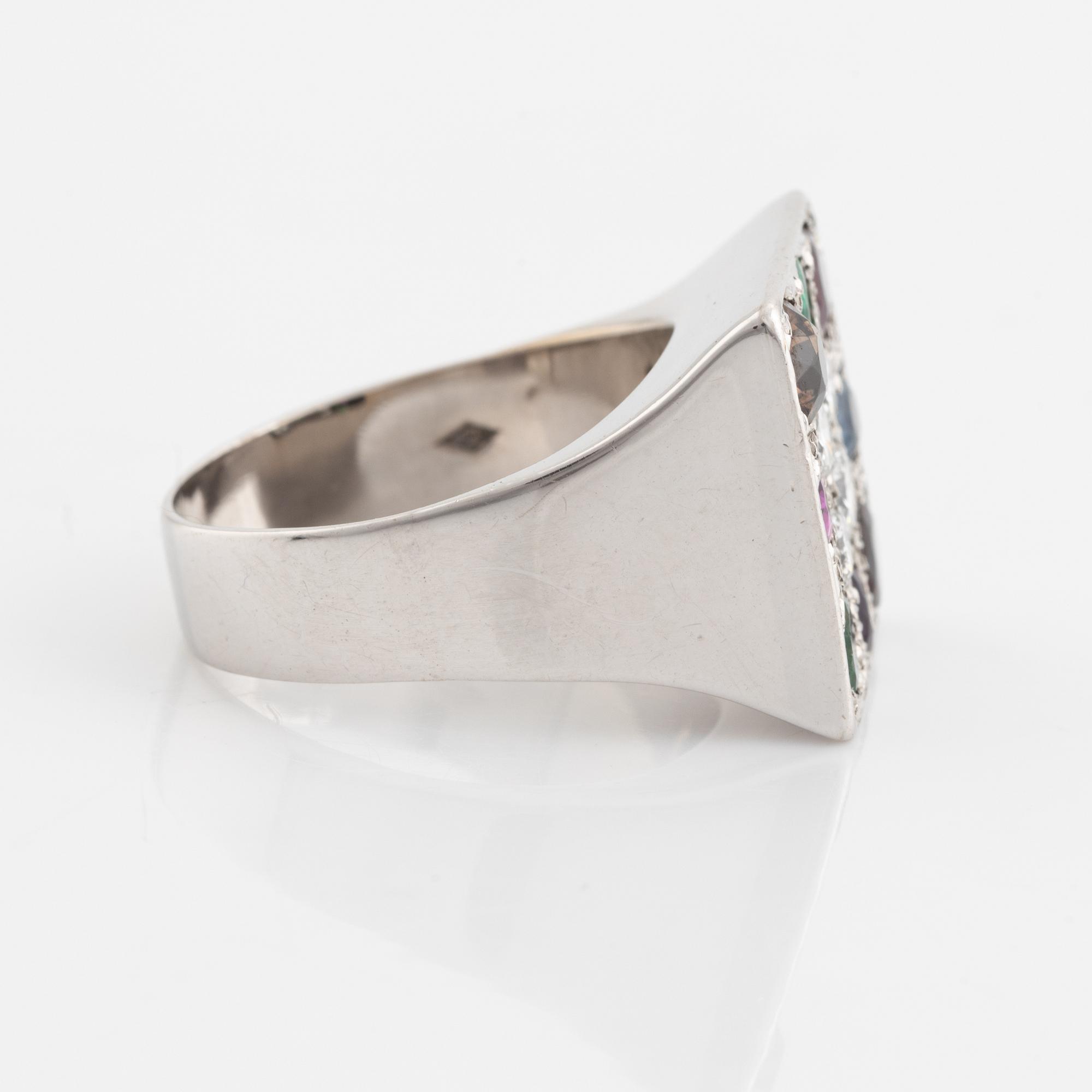 An 18K white gold ring set with round brilliant-cut diamonds and colored stones.
