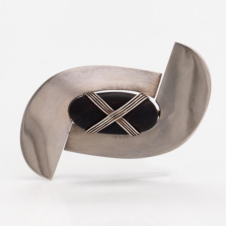 Paula Häiväoja, a sterling silver brooch with a natural stone "kiveen sidottu musta". Pentti Roos/Studio Paula, Helsinki.