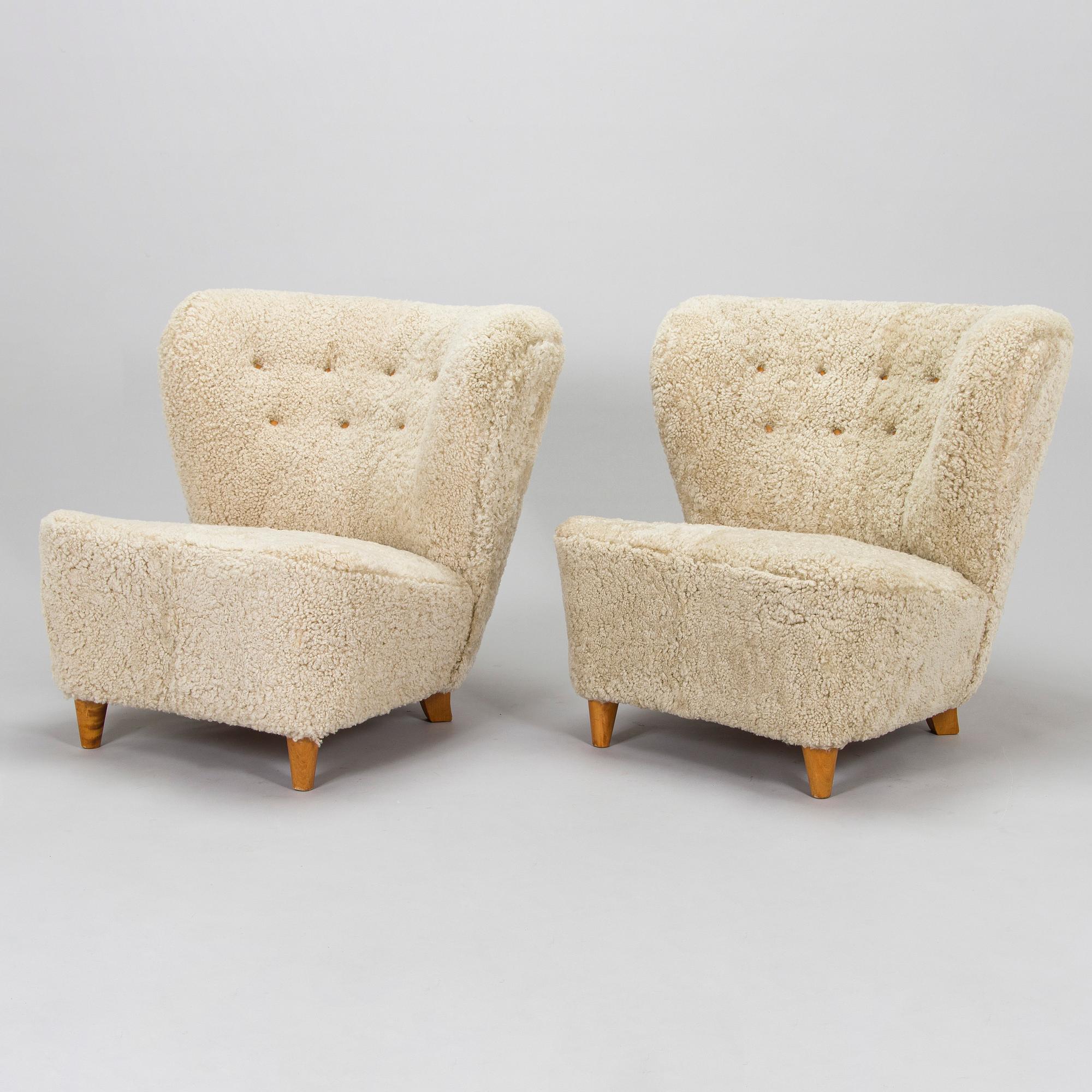 A pair of mid-20th century armchairs in sheepskin.
