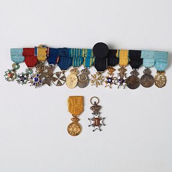 SLÄPSPÄNNE MED 15 MINIATYRTECKEN,   bla silver, mest Sverige, 1900-tal.