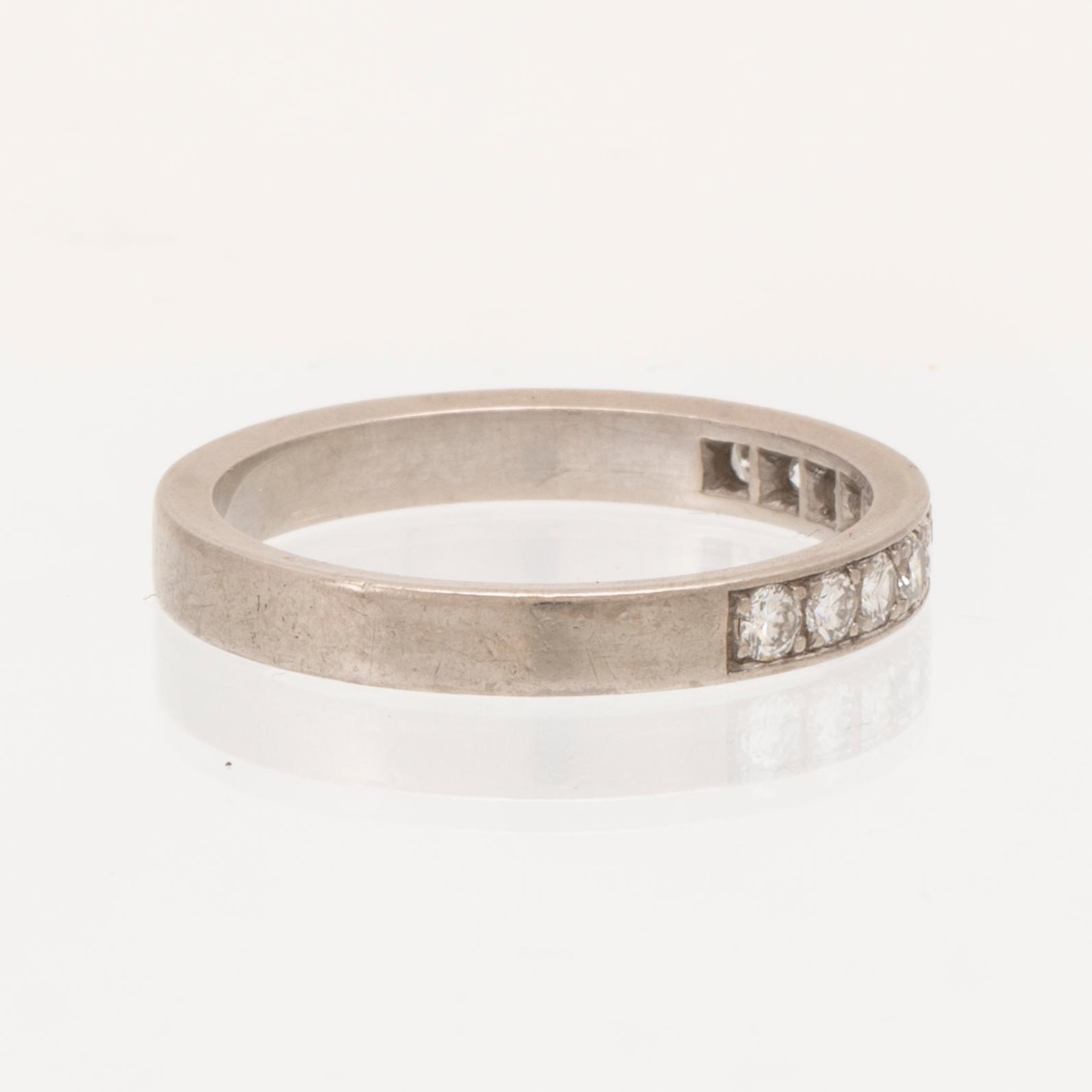 An 18K white gold half eternity ring set with round brilliant-cut diamonds.