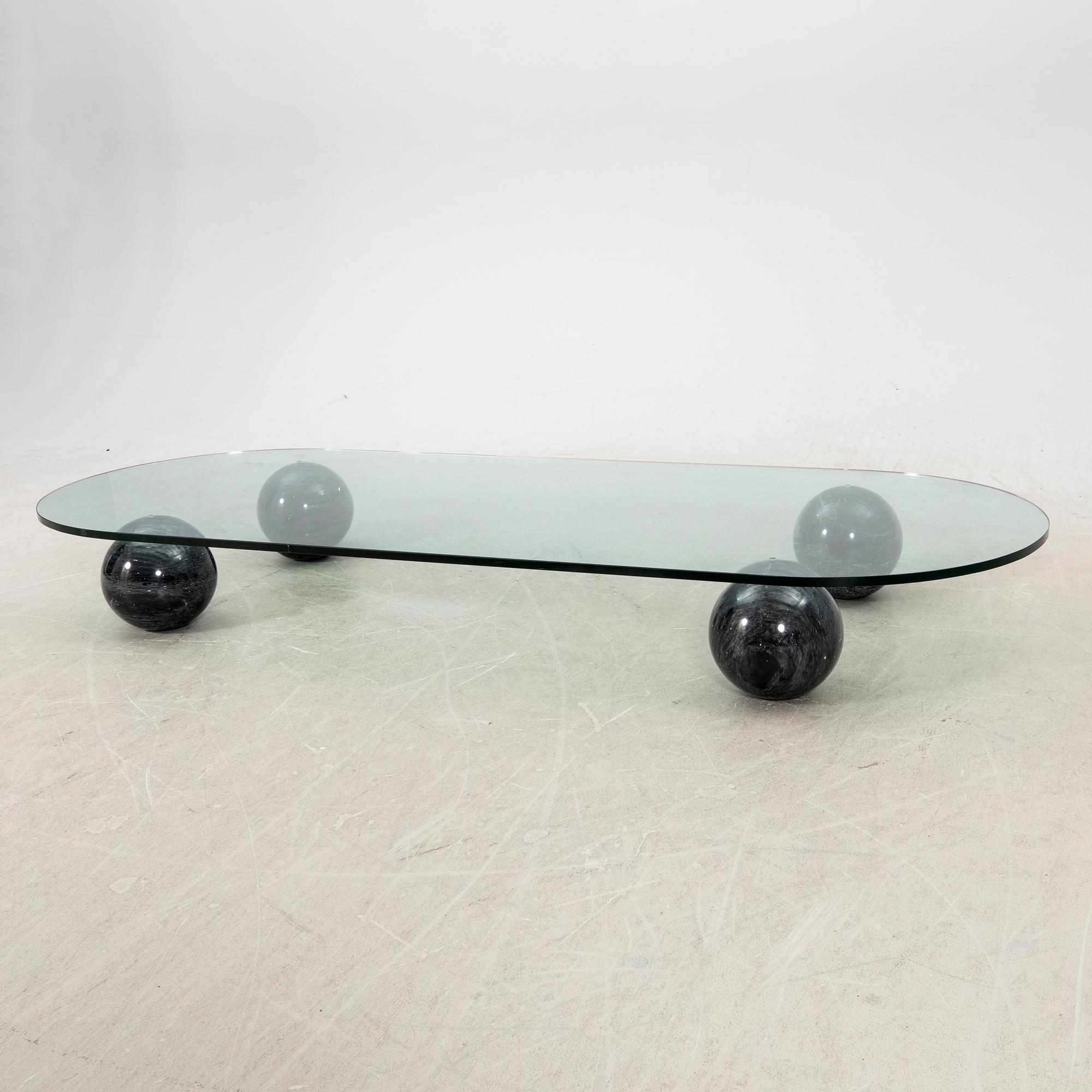 A glass and stone table from the late 20th century.