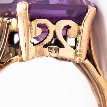 A 9-14K gold ring with a synthetic sapphire.