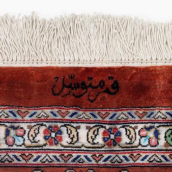 A signed pictoral silk Qum rug, c. 203 x 127 cm.