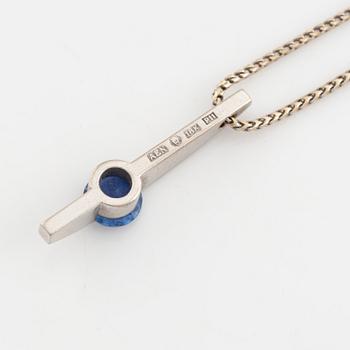 An 18K white gold necklace with a faceted sapphire and brilliant cut diamonds.