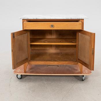 An early 1900s oak and marble cabinet.