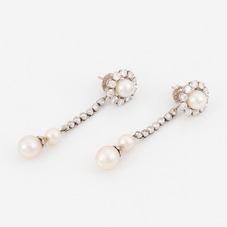 A pair of 18K white gold and cultured bouton pearl earrings set with round brilliant-cut diamonds.