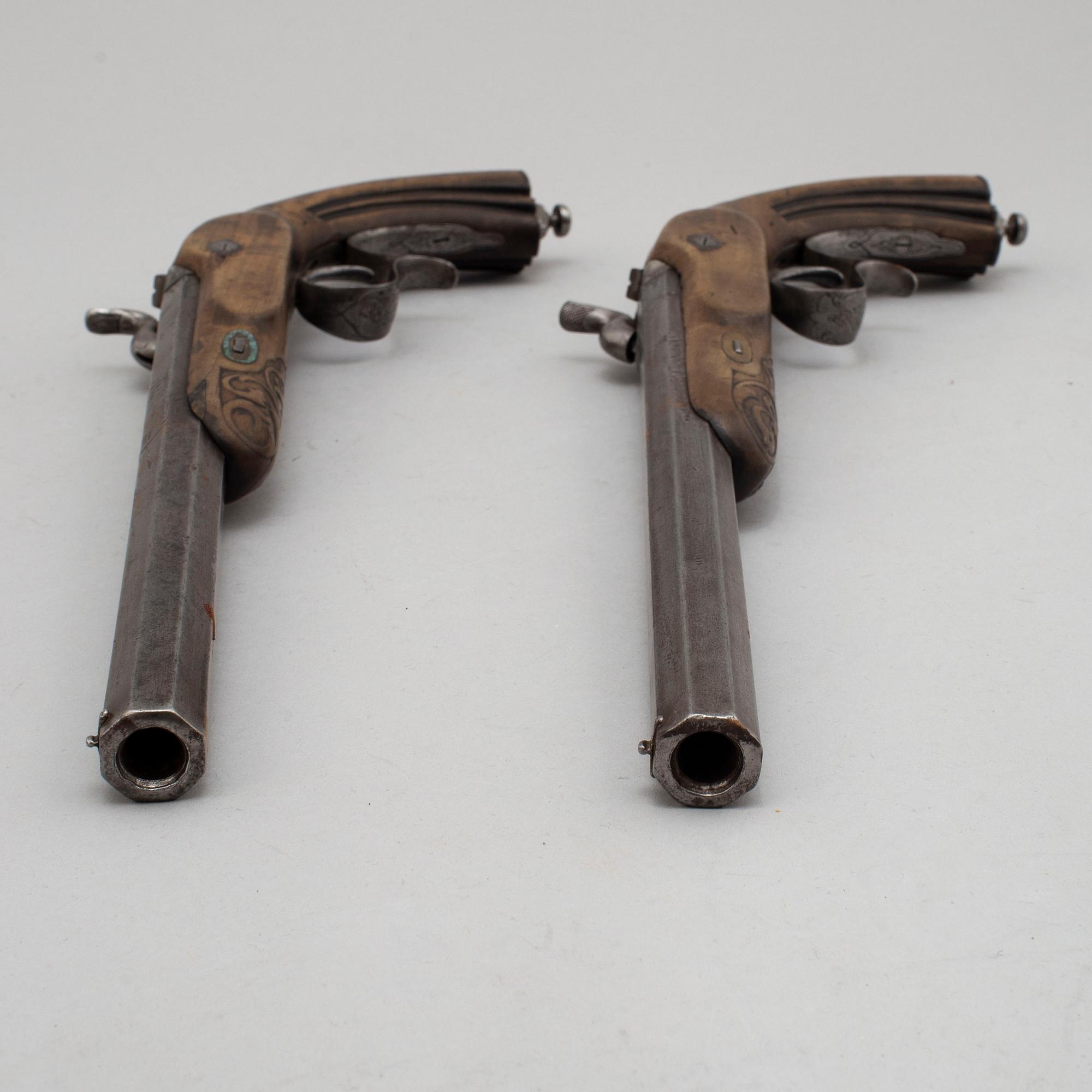 A pair of mid 19th century percussion pistols in a case marked Campagnac a Bordeaux.