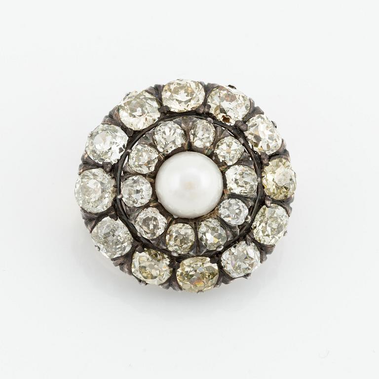 A silver and gold brooch, with cushion-cut diamonds and a pearl.