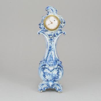 An 18th Century table clock, by Jacob Koch (1737-1805), Stockholm. Case in rococo-style, faience, marked AK.