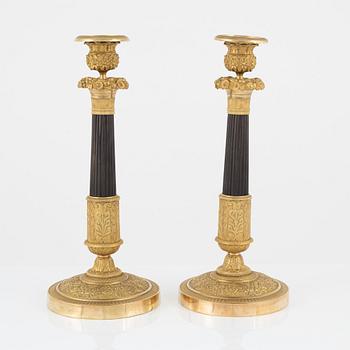 A pair of French Empire ormolu and patinated bronze candlesticks, early 19th century.