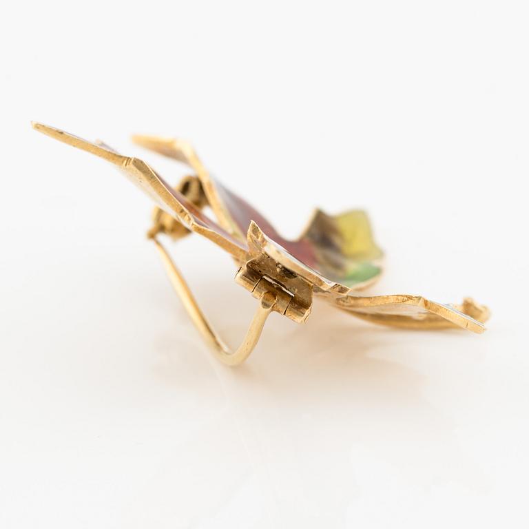 A W.A. Bolin brooch 18K gold and enamel with a round brilliant-cut diamond.