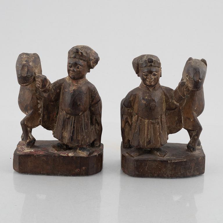 A pair of wooden sculptures of men with horses, late Qing dynasty / around 1900.